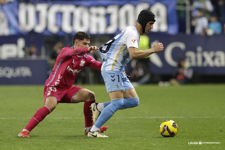 Aarón Martín agarra a Luismi Sánchez durante el partido en La Rosaleda (La Liga)