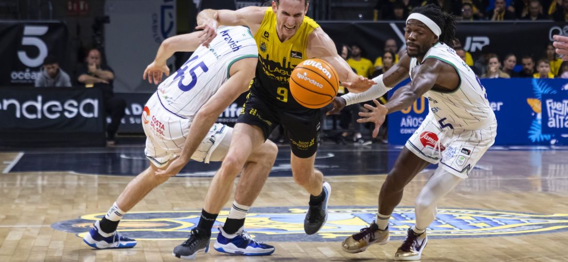 Marcelinho Huertas intenta zafarse de la defensa de Unicaja (ACB Media)