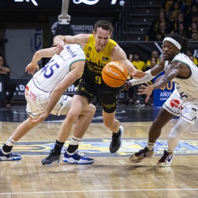 Marcelinho Huertas intenta zafarse de la defensa de Unicaja (ACB Media)