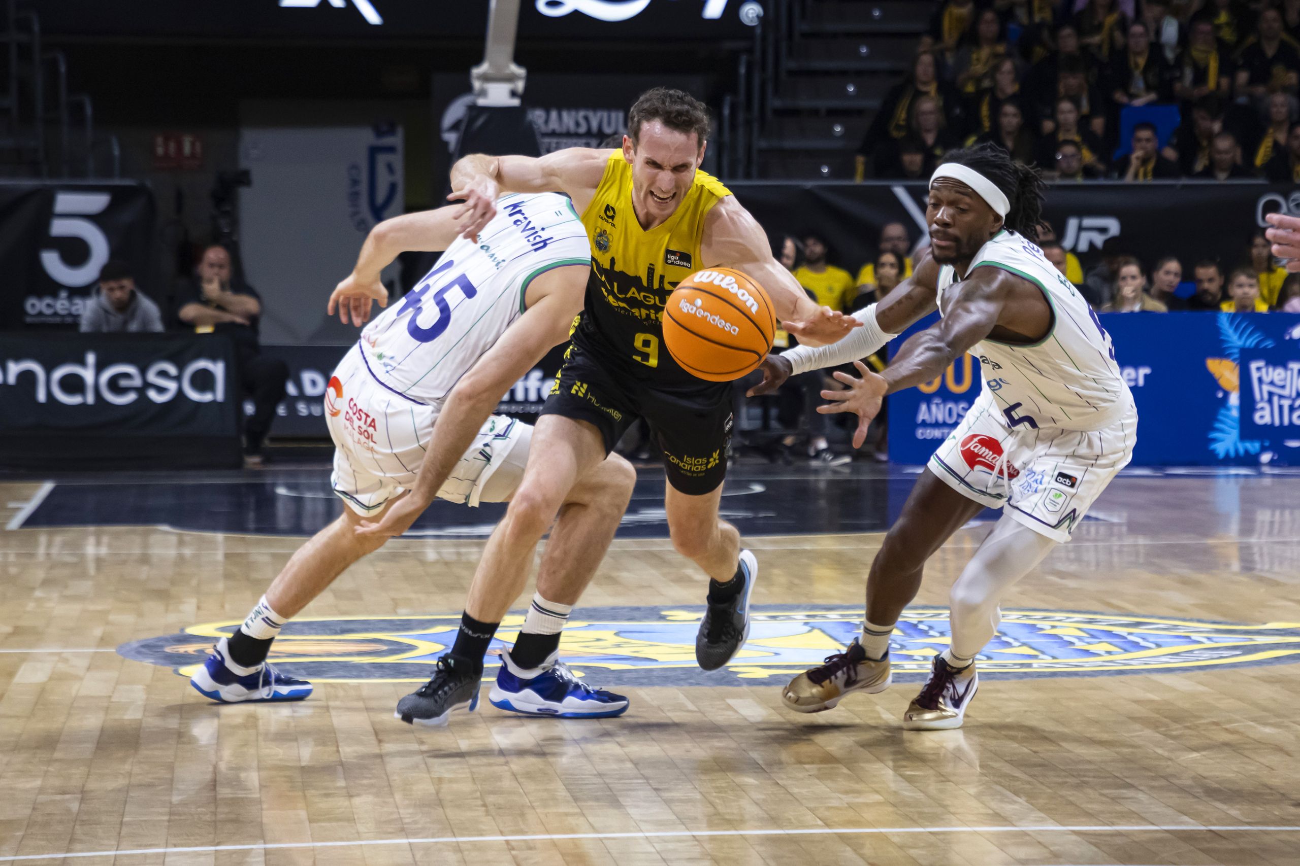Marcelinho Huertas intenta zafarse de la defensa de Unicaja (ACB Media)